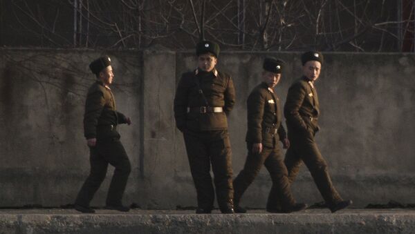North Korean soldiers walk along the river bank of the North Korean town of Sinuiju, opposite side to the Chinese border city of Dandong, Tuesday, Dec. 20, 2011 - Sputnik International