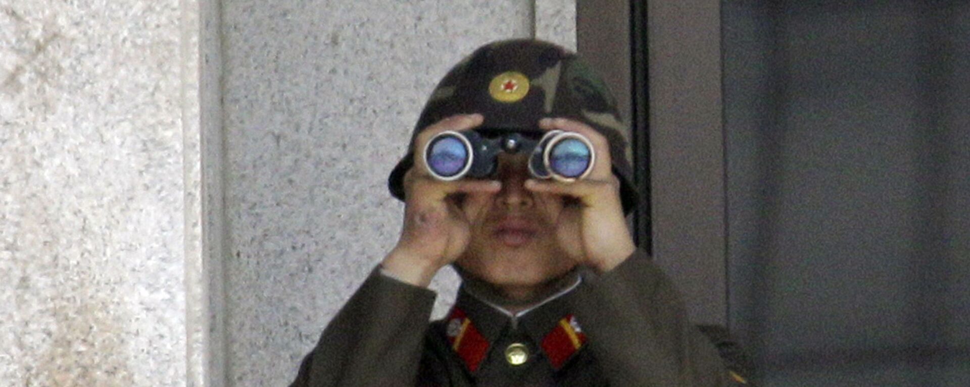 A North Korean soldier looks at the southern side through telescopes at the border village of the Panmunjom (DMZ) that separates the two Koreas since the Korean War, in Paju, north of Seoul, South Korea, Tuesday, May 24, 2011 - Sputnik International, 1920, 19.07.2023