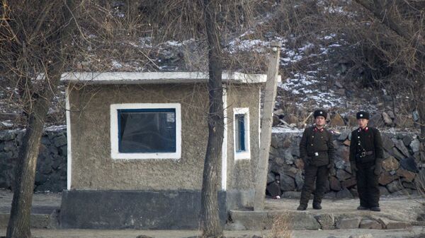 North Korean soldiers look as they stand guard along the river bank of the North Korean town of Sinuiju, opposite side to the Chinese border city of Dandong, Tuesday, Dec. 20, 2011 - Sputnik International