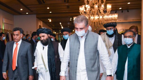 Pakistan's Foreign Minister Shah Mahmood Qureshi walks with Mullah Abdul Ghani Baradar (2nd L), the leader of the Taliban delegation, upon his arrival at the Ministry of Foreign Affairs (MOFA) office in Islamabad, Pakistan August 25, 2020.  - Sputnik International