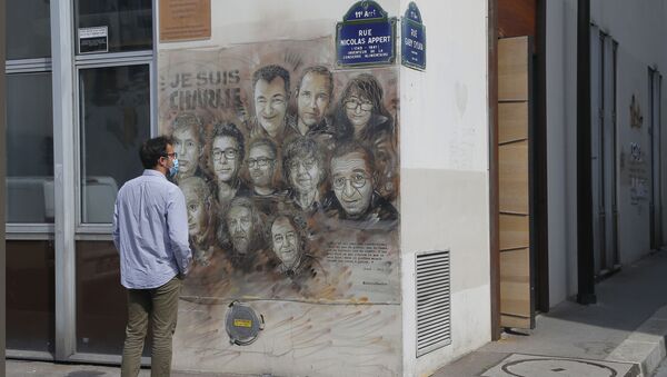 A man wearing a protective face mask as a precaution against the coronavirus looks on a painting by French street artist Christian Guemy, a.k.a. 'C215' in Paris Wednesday, Sept. 2, 2020, in tribute to the members of the satirical newspaper Charlie Hebdo attack by jihadist gunmen in January 2015. Thirteen men and a woman go on trial Wednesday over the 2015 attacks against a satirical newspaper and a kosher supermarket in Paris that marked the beginning of a wave of violence by the Islamic State group in Europe. Seventeen people and all three gunmen died during the three days of attacks in January 2015 - Sputnik International