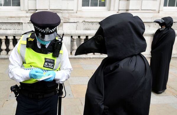 A police officer takes down details of one of the members of the Animal Rebellion group dressed in a costume as they march during an Extinction Rebellion protest in London, Britain, September 8, 2020 - Sputnik International