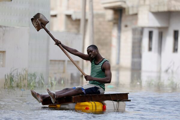 A resident shows his shovel that he uses to row through flooded streets after last week's heavy rains in Keur Massar, Senegal September 8, 2020 - Sputnik International
