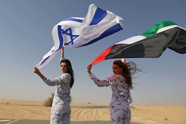 Israeli model May Tager, holding an Israeli flag, poses with Dubai-resident model Anastasia, holding an Emirati flag, during a photoshoot for FIX's Princess Collection in Dubai, United Arab Emirates, September 8, 2020 - Sputnik International