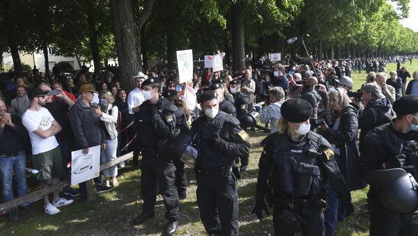 Police officers observe participants of a demonstration against the anti-Corona measures of politics at the edge of the Theresienwiese in Munich, Germany, Saturday, May 16, 2020 - Sputnik International