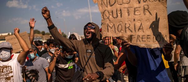 Refugees and migrants from the Moria camp protest near Mytilene on the Greek island of Lesbos, on September 12, 2020, a few days after a fire destroyed the Moria refugee camp Refugees and migrants from the Moria camp protest near Mytilene on the Greek island of Lesbos, on September 12, 2020, a few days after a fire destroyed the Moria refugee camp - Sputnik International