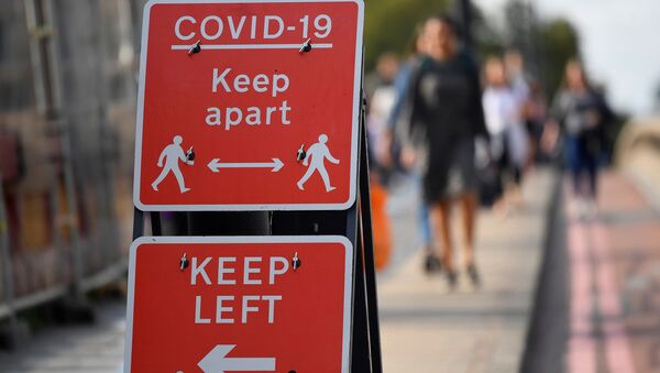 Pedestrians walk near public health signs - Sputnik International