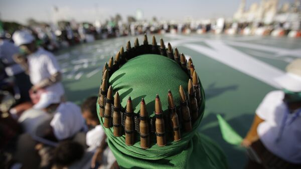 A supporter of Shiite rebels, known as Houthis, with an ammunition belt placed on his head attends a celebration of Moulid al-nabi, the birth of Islam's prophet Muhammad in Sanaa, Yemen, Saturday, Nov. 9, 2019 - Sputnik International