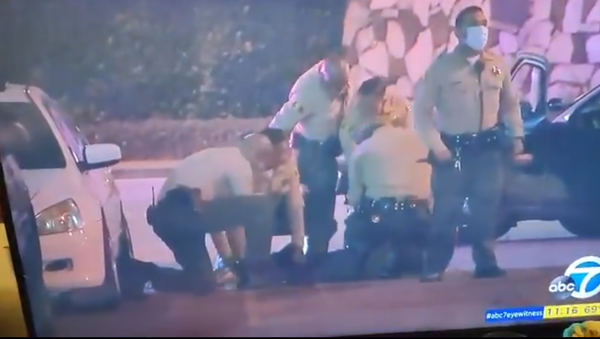 Screenshot from an ABC TV report revealing police officers detaining a reporter during protests in Los Angeles - Sputnik International