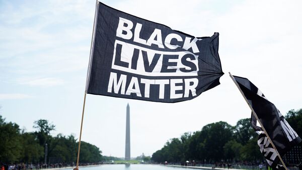 A demonstrator holds a BLM flag during a Get Your Knee Off Our Necks march in front of the Lincoln Memorial in support of racial justice that is expected to gather protestors from all over the country in Washington, U.S., August 28, 2020.  - Sputnik International