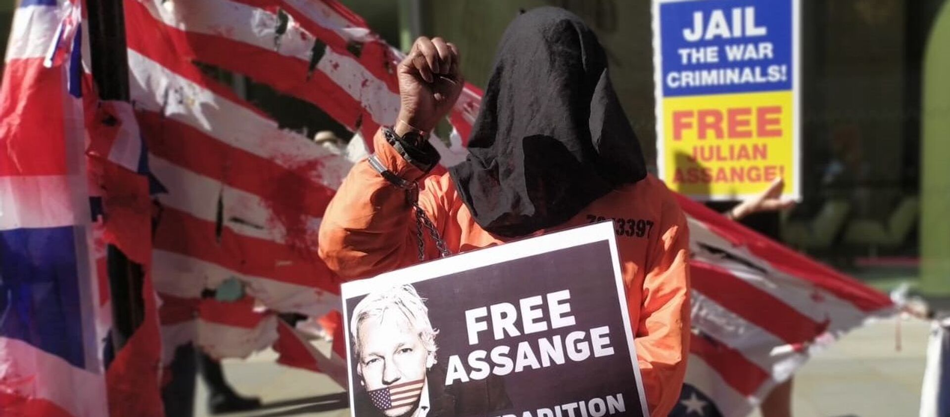 Hooded protester in orange jump suit across from the Old Bailey holding a 'Free Assange' banner - Sputnik International, 1920, 14.09.2020
