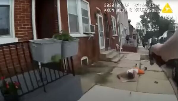 A man lies on the ground after being shot by a police officer in Lancaster, Pennsylvania, U.S., in this still image taken from a body camera footage on September 13, 2020. - Sputnik International