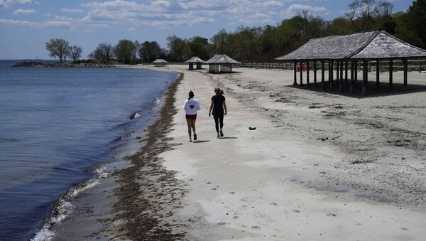 Women walk  along the beach on the Long Island Sound on Tod's Point in Old Greenwich, Connecticut on May 7, 2020. - Sputnik International
