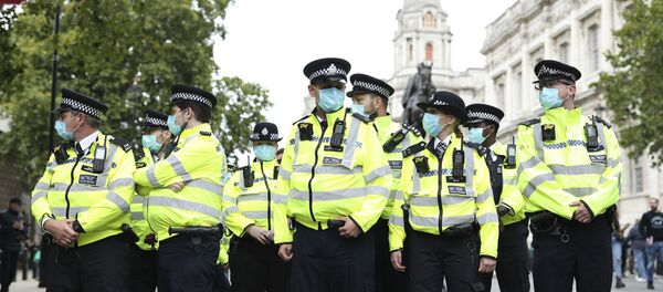 Police officers wearing face masks stand guard during a protest opposed to COVID-19 pandemic restrictions, in Trafalgar Square, London, 29 August, 2020 Police officers wearing face masks stand guard during a protest opposed to COVID-19 pandemic restrictions, in Trafalgar Square, London, 29 August, 2020 - Sputnik International