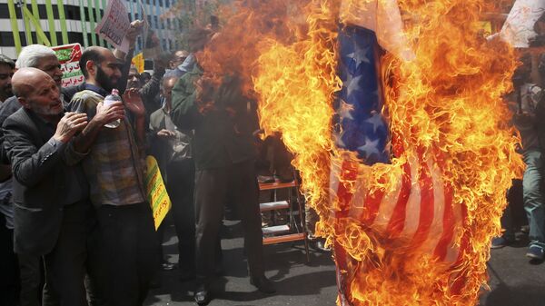 Iranian protestors burn a likeness of a U.S. flag during a gathering after their Friday prayer in Tehran, Iran, 11 May 2018 - Sputnik International