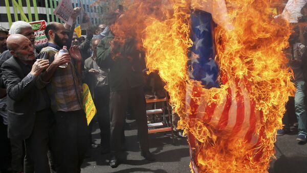 Iranian protestors burn a likeness of a U.S. flag during a gathering after their Friday prayer in Tehran, Iran, 11 May 2018 - Sputnik International