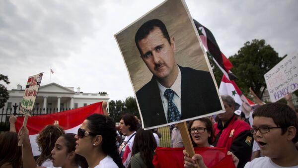 Protesters carry an image of Syrian President Bashar Hafez al-Assad during a demonstration against US military action in Syria, Monday, Sept. 9, 2013, in front of the White House in Washington. On Tuesday, President Barack Obama will address the nation regarding Syria - Sputnik International