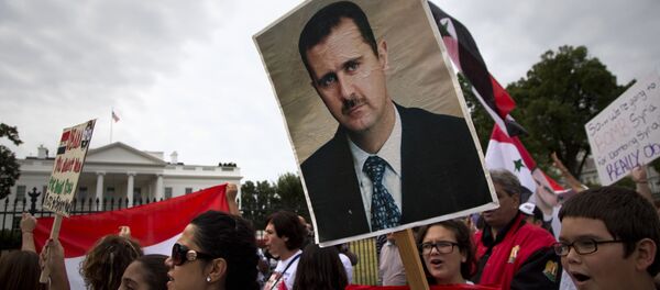 Protesters carry an image of Syrian President Bashar Hafez al-Assad during a demonstration against US military action in Syria, Monday, Sept. 9, 2013, in front of the White House in Washington. On Tuesday, President Barack Obama will address the nation regarding Syria Protesters carry an image of Syrian President Bashar Hafez al-Assad during a demonstration against US military action in Syria, Monday, Sept. 9, 2013, in front of the White House in Washington. On Tuesday, President Barack Obama will address the nation regarding Syria - Sputnik International