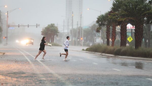  People run across a road through the rain and wind as the outer bands of Hurricane Sally come ashore on September 15, 2020 in Gulf Shores, Alabama - Sputnik International