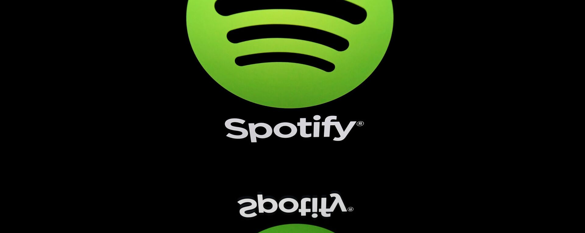 This combination created on March 13, 2019 of file illustrations displayed on tablet screens shows the logo of the US multinational technology company Apple (bottom, February 18, 2019 in Paris) and the logo of online streaming music service Spotify (April 19, 2018 in Paris). - Swedish music streaming giant Spotify said on March 13, 2019 it had filed a formal complaint with the EU Commission against Apple, accusing its US rival of stifling competition in the online music market. - Sputnik International, 1920, 16.09.2020