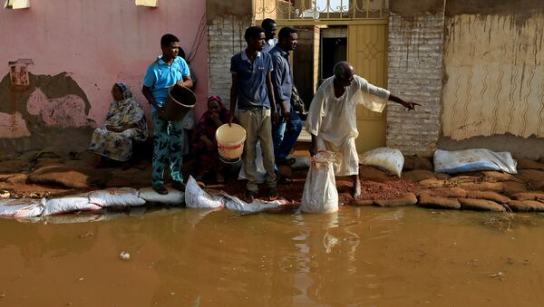 Residents pour out the waters of the Blue Nile floods from their backyard within the Al-Ikmayr area of Omdurman in Khartoum, Sudan August 27, 2020.  - Sputnik International