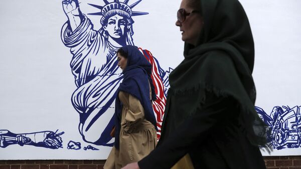 People walk past a satirical drawing of Statue of Liberty after new anti-U.S. murals on the walls of former U.S. embassy unveiled in a ceremony in Tehran, Iran, Saturday, Nov. 2, 2019 - Sputnik International