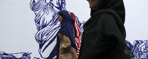 People walk past a satirical drawing of Statue of Liberty after new anti-U.S. murals on the walls of former U.S. embassy unveiled in a ceremony in Tehran, Iran, Saturday, Nov. 2, 2019 - Sputnik International