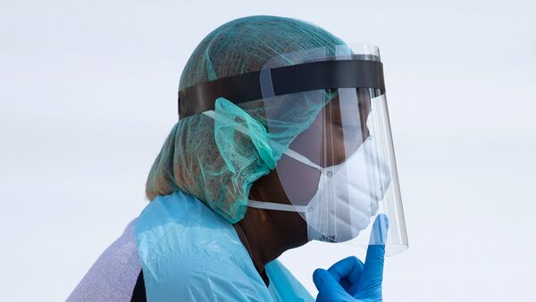  A healthcare worker points to her mask, while requesting a resident to lower their mask to their mouth, at a coronavirus disease (COVID-19) drive in testing location in Houston, Texas, U.S., August 18, 2020. - Sputnik International