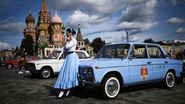 A girl stands in front of a classic Russian car on Red Square for the GUM Autorally. - Sputnik International