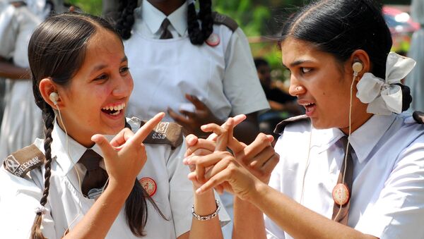 Hearing and speech impaired students Poonam Sharma, left, and Deepika interact with each other using sign language before an awareness rally for World Mental Health Week in Hyderabad, India, Saturday, Oct. 14, 2006 - Sputnik International