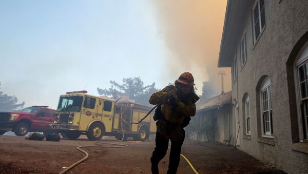 A firefighter carries a hose while defending the Mount Wilson observatory during the Bobcat Fire in Los Angeles, California, U.S., 17 September 2020. - Sputnik International
