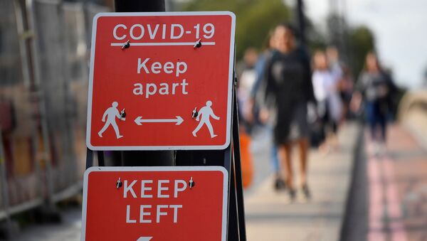 Pedestrians walk near public health signs, whilst the reproduction R number of COVID-19 infections in the United Kingdom has risen and may be above 1, the Government Office for Science said on Friday, indicating a risk that the overall epidemic is growing, London, Britain, September 11, 2020 - Sputnik International
