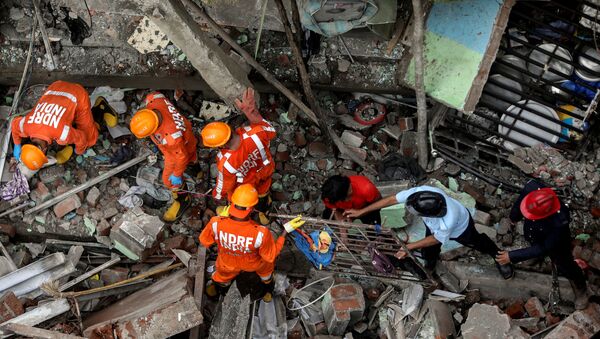 National Disaster Response Force (NDRF) officials and firemen remove debris as they look for survivors after a three-storey residential building collapsed in Bhiwandi on the outskirts of Mumbai, India, September 21, 2020.  - Sputnik International