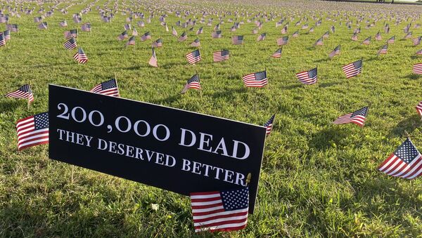 A sign near the Washington Monument reads, 200,000 dead. They deserved better. Each flag in the installation represents 10 Americans who died of COVID-19. - Sputnik International