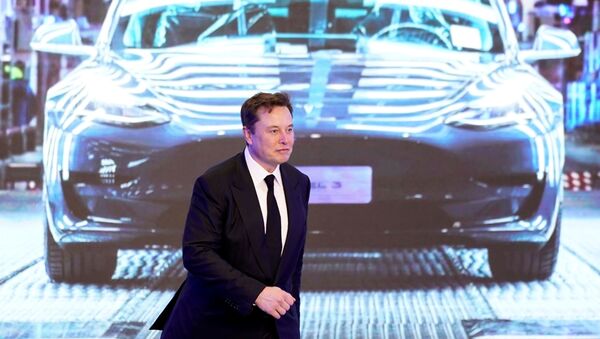  Tesla Inc CEO Elon Musk walks next to a screen showing an image of Tesla Model 3 car during an opening ceremony for Tesla China-made Model Y program in Shanghai, China January 7, 2020 - Sputnik International