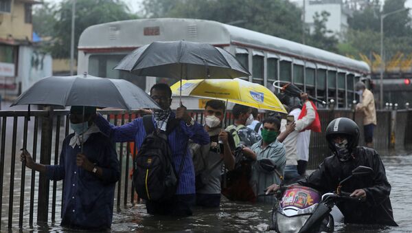 People wade through a waterlogged road after heavy rainfall in Mumbai, India, September 23 2020. - Sputnik International