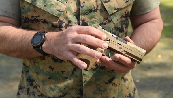US military service member holds SIG Sauer M18 handgun. - Sputnik International