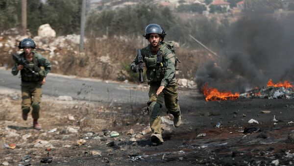 Israeli soldiers run towards demonstrators during a Palestinian protest against normalizing ties with Israel, in Kafr Qaddum town in the Israeli-occupied West Bank September 11, 2020 - Sputnik International