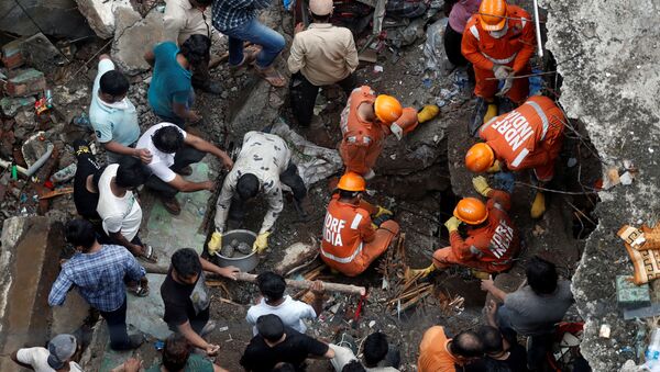 FILE PHOTO: National Disaster Response Force (NDRF) officials search for survivors as people help clear the rubble after a three-storey building collapsed in Bhiwandi, on the outskirts of Mumbai, India, September, 21 2020.  - Sputnik International
