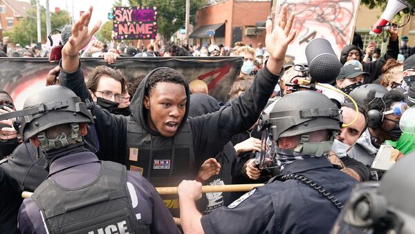 A protester clashes with police after a grand jury considering the March killing of Breonna Taylor, a Black medical worker, in her home in Louisville, Kentucky, voted to indict one of three white police officers for wanton endangerment, in Louisville, Kentucky, U.S. September 23, 2020. - Sputnik International