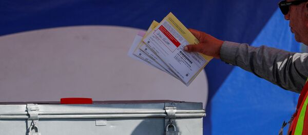 An election worker places mail-in ballots into an election box at a drive-through drop off location at the Registrar of Voters in San Diego, California, U.S. November 5, 2018. - Sputnik International