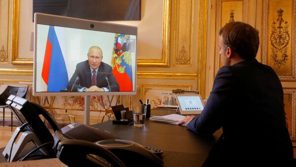 French President Emmanuel Macron listens to Russian President Vladimir Putin during a video conference at the Elysee Palace in Paris, France, June 26, 2020.  - Sputnik International