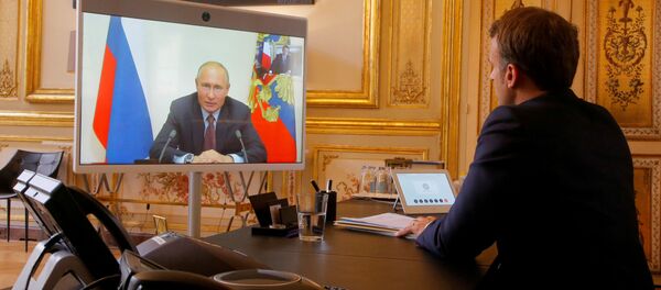 French President Emmanuel Macron listens to Russian President Vladimir Putin during a video conference at the Elysee Palace in Paris, France, June 26, 2020.  - Sputnik International