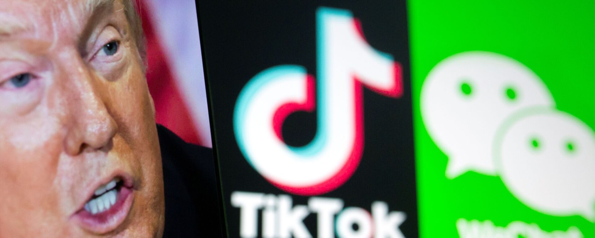 A picture of U.S. President Donald Trump is seen on a smartphone in front of displayed Tik Tok and WeChat logos in this illustration taken September 18, 2020. - Sputnik International, 1920, 24.09.2020