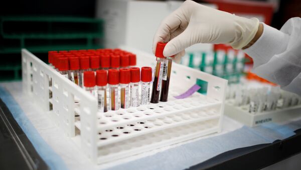 A health worker takes test tubes with plasma and blood samples after a separation process in a centrifuge during a coronavirus disease (COVID-19) vaccination study at the Research Centers of America, in Hollywood, Florida, U.S., September 24, 2020. - Sputnik International