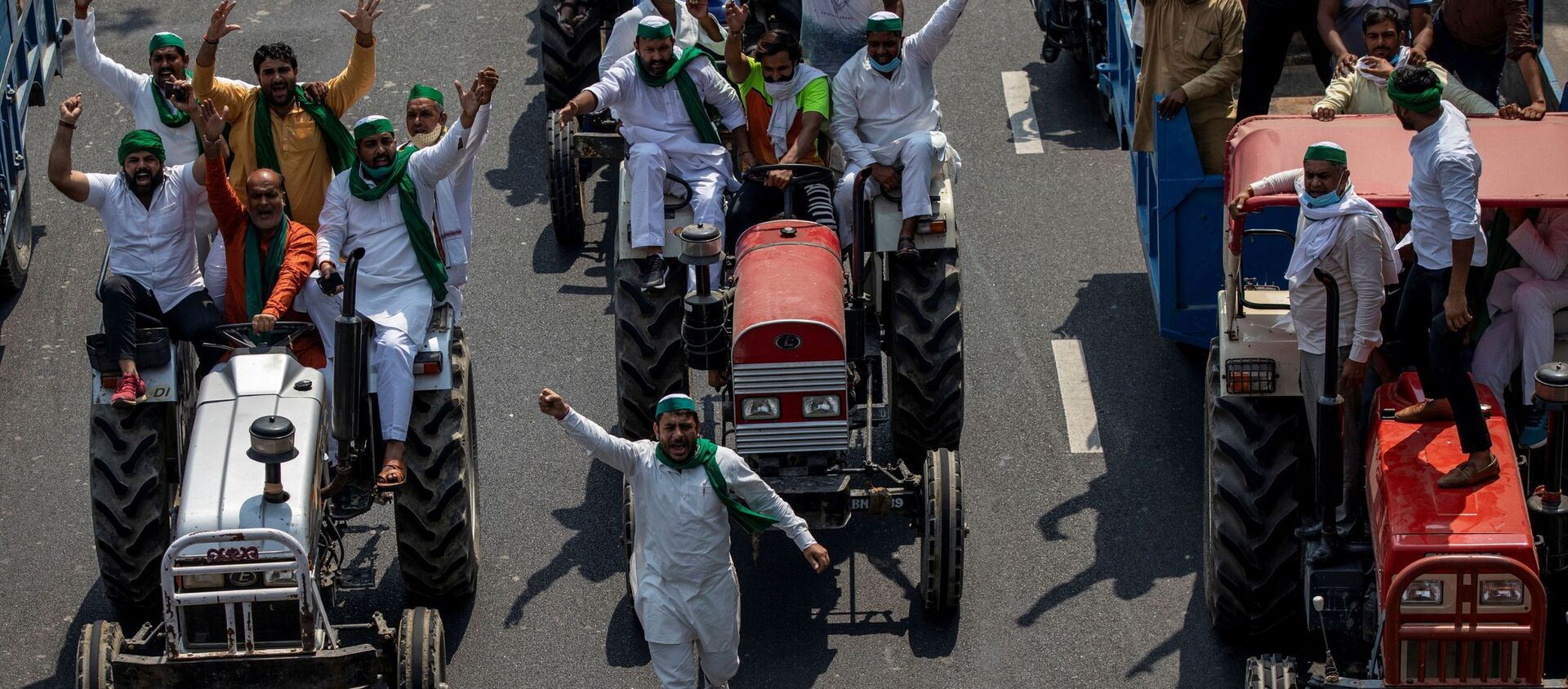 Farmers on tractors shout slogans as they arrive to block the Delhi-Uttar Pradesh border during a protest against farm bills passed by India's parliament - Sputnik International, 1920, 04.10.2020
