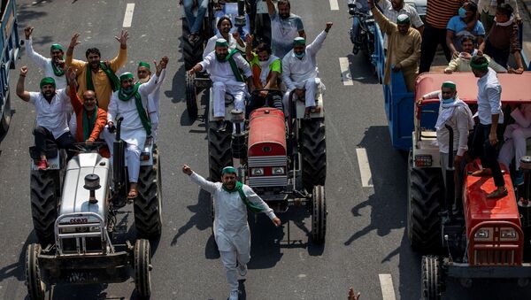 Farmers on tractors shout slogans as they arrive to block the Delhi-Uttar Pradesh border during a protest against farm bills passed by India's parliament - Sputnik International