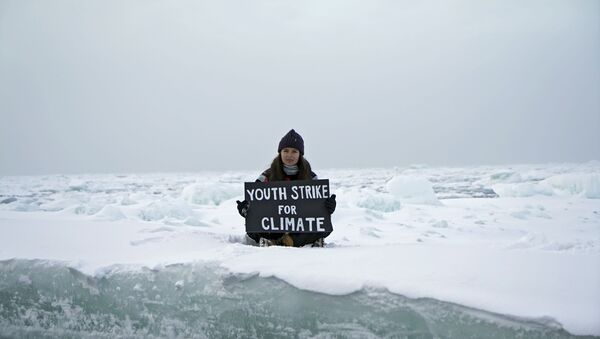 Environmental activist and campaigner Mya-Rose Craig, 18, holds a cardboard sign reading youth strike for climate as she sits on the ice floe in the middle of the Arctic Ocean, hundreds of miles above the Arctic Circle, 20 September 2020. - Sputnik International