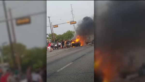 Screenshot of the video showing a fiery incident involving multiple vehicles in Dallas, where the police officers, with the help of the community members, saved an unconscious man from a burning car - Sputnik International