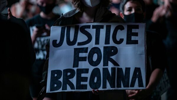 A woman holds a sign during the march for Breonna Taylor - Sputnik International